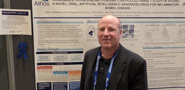 Allan Pantuck, MD in front of poster with blue ribbon award
