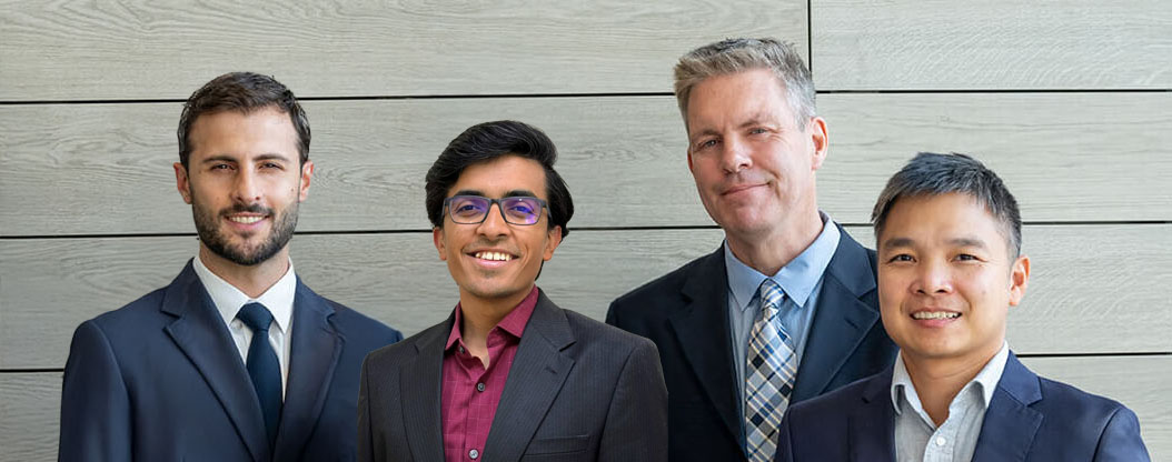 Computational Biology and Artificial Intelligence group photo in suits in front of gray wall